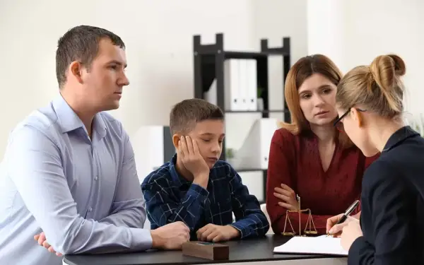 Rodzina z dzieckiem rozmawia z prawniczką o tym, ile trwa nadzór kuratora nad nieletnim.
